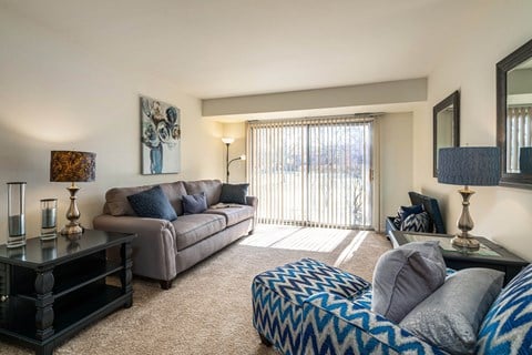 a living room with a couch and a chair and a sliding glass door